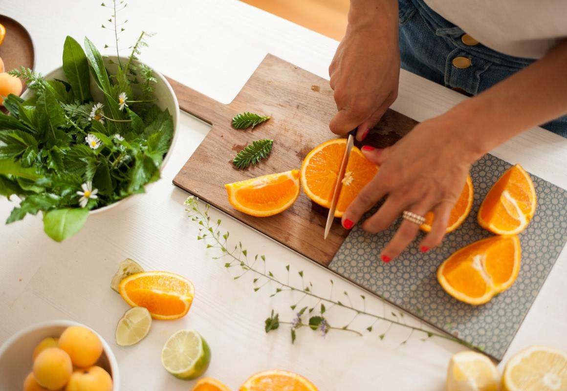 Carla prepares the ingredients for a green smoothie - including oranges, wild herbs.